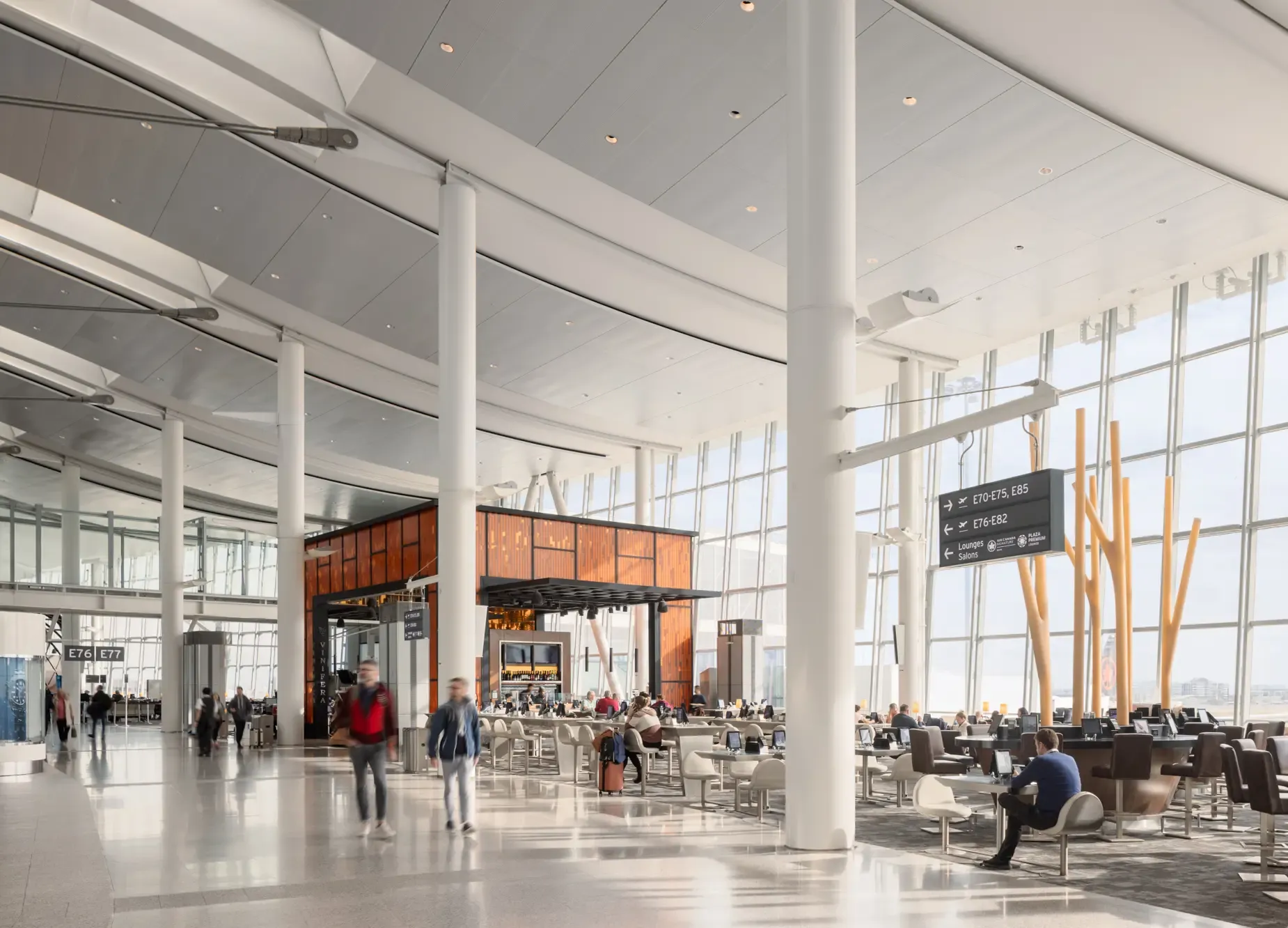 Spacious terminal at Toronto Pearson Airport with seating, dining area, and large windows.