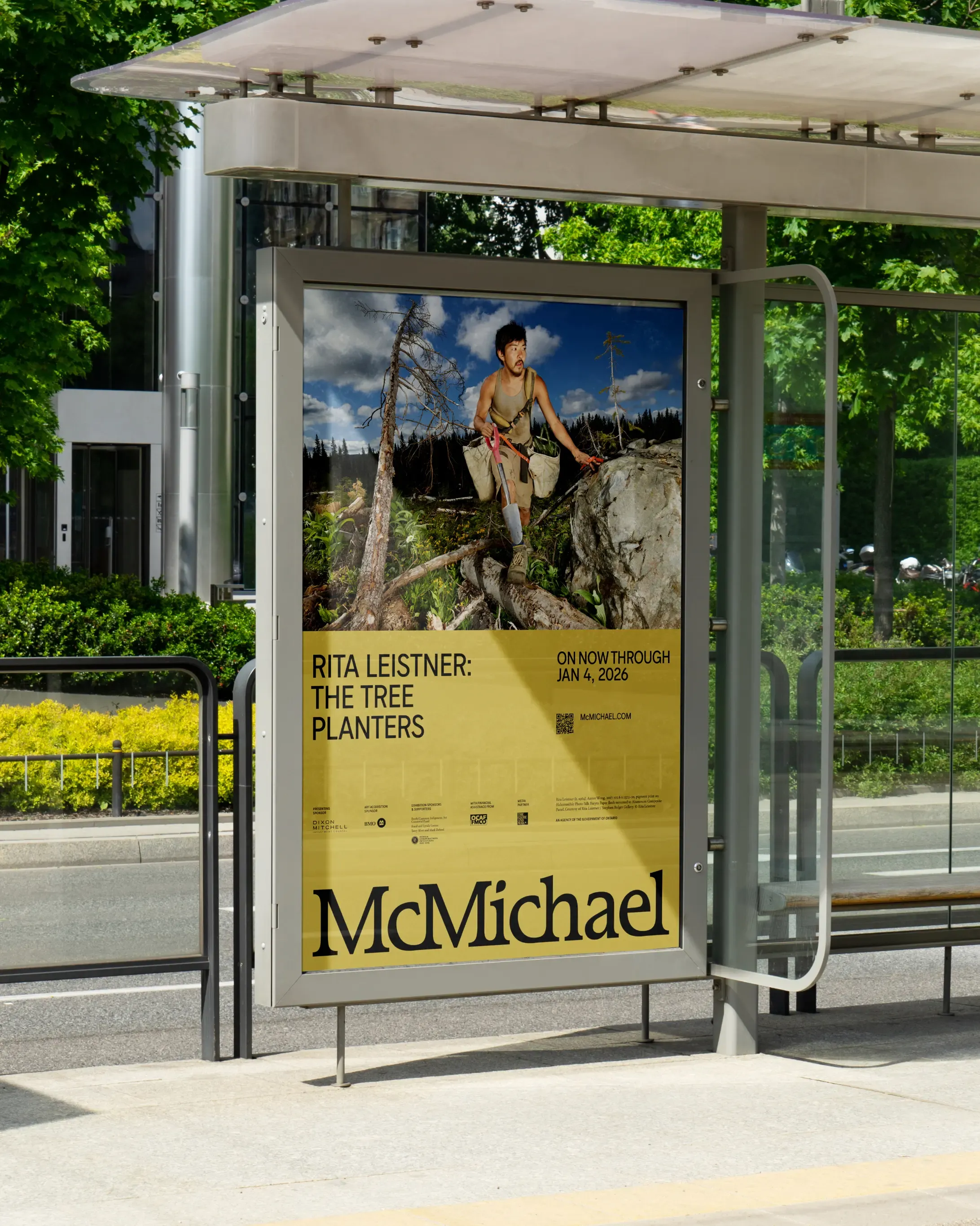 Branded bus shelter advertisement with the McMichael logo, an image by Rita Leistner, and the words