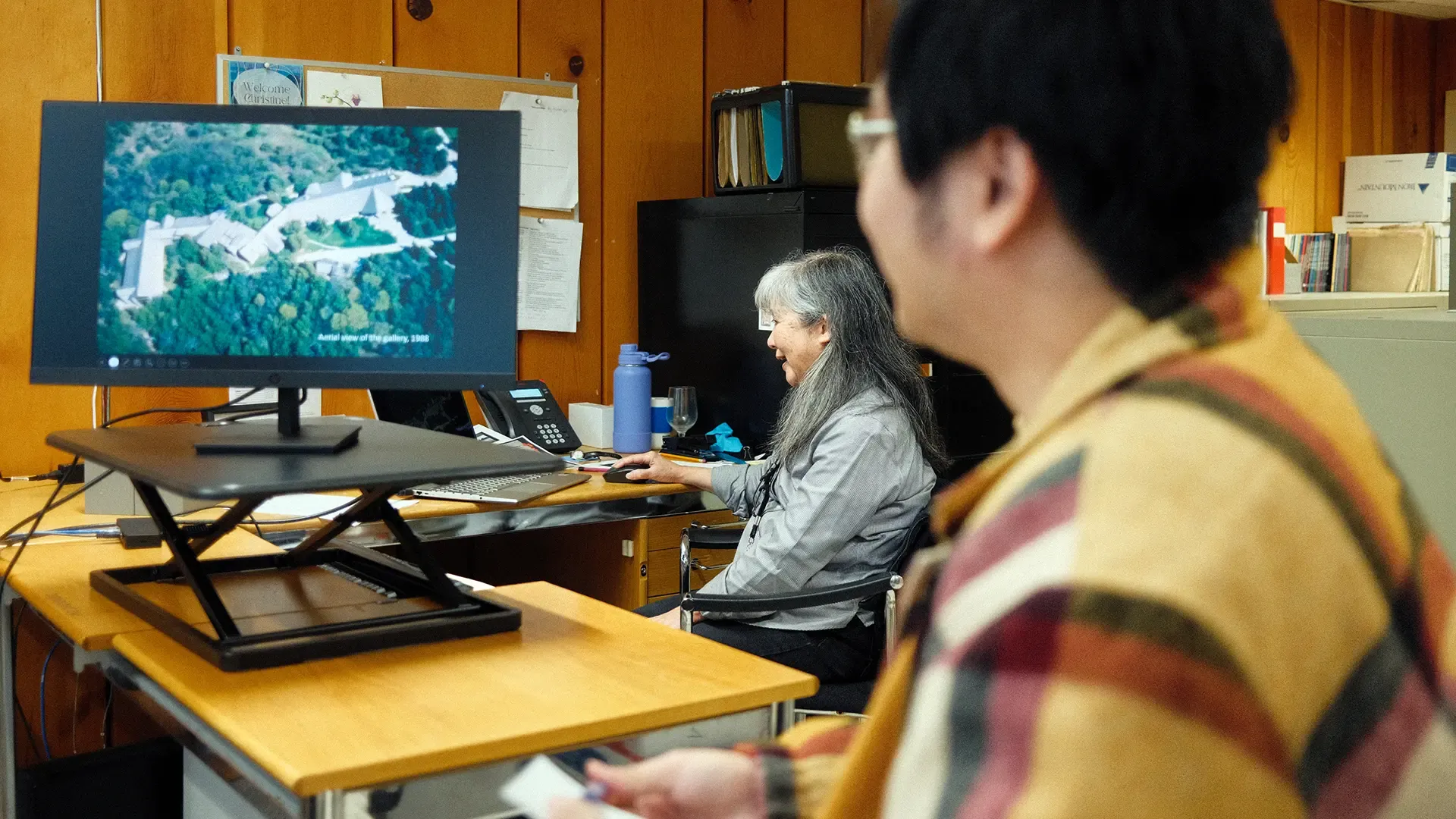 Woman sits at a computer inside the McMichael museum.